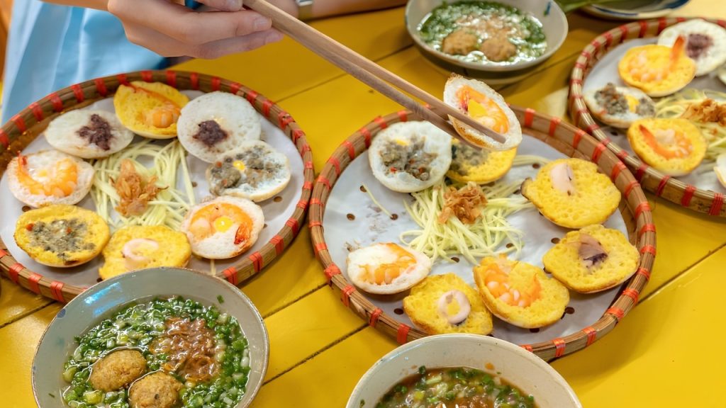 Bánh căn Ngọc Đà Lạt với nhân trứng và hải sản đúc nóng trên khuôn bánh