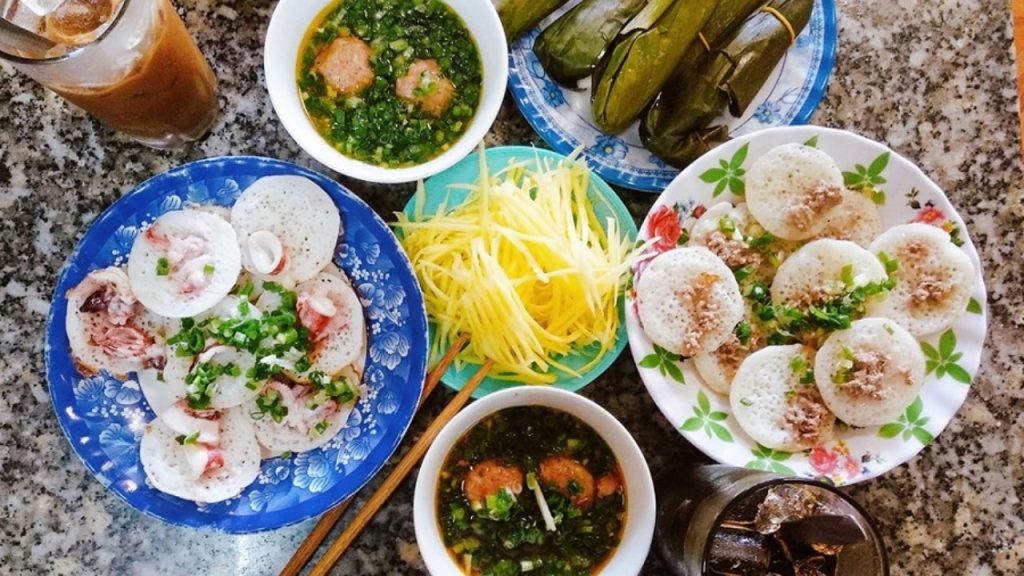 Bánh căn Đà Lạt chấm nước mắm hoặc mắm nêm ăn cùng xíu mại và xoài xanh