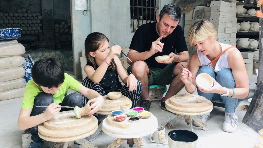 Du khách trải nghiệm xoay gốm thủ công tại làng nghề truyền thống Bát Tràng